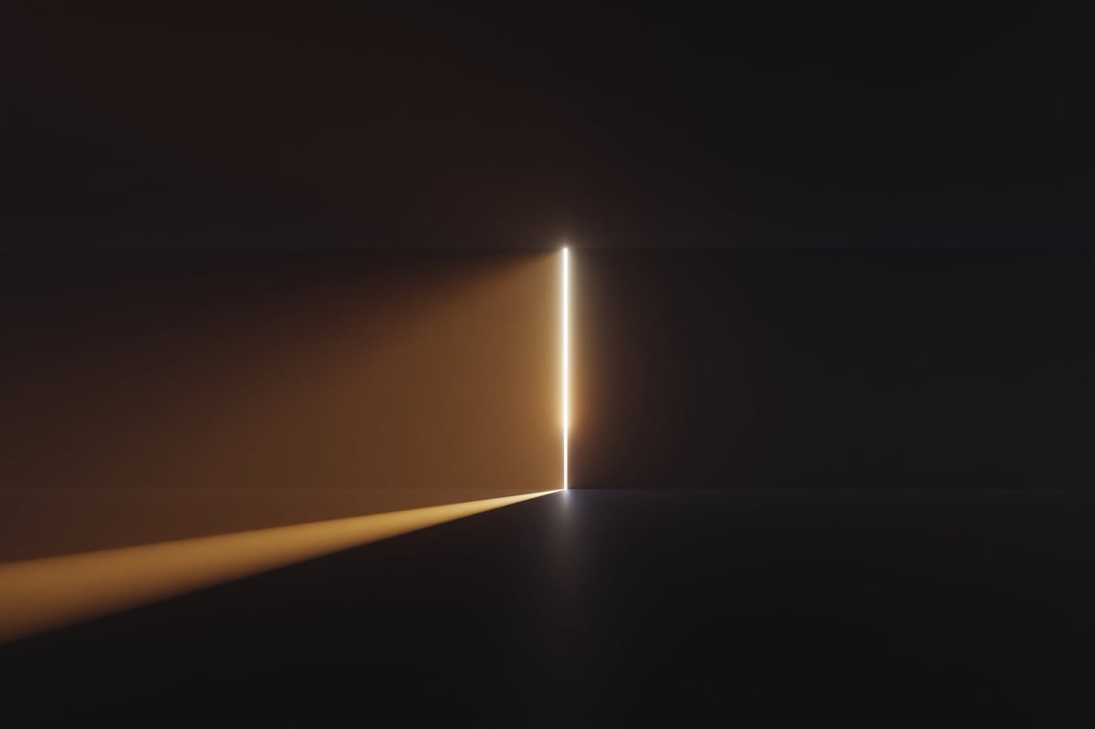 A beam of light streaming through an opening in an abstract wall